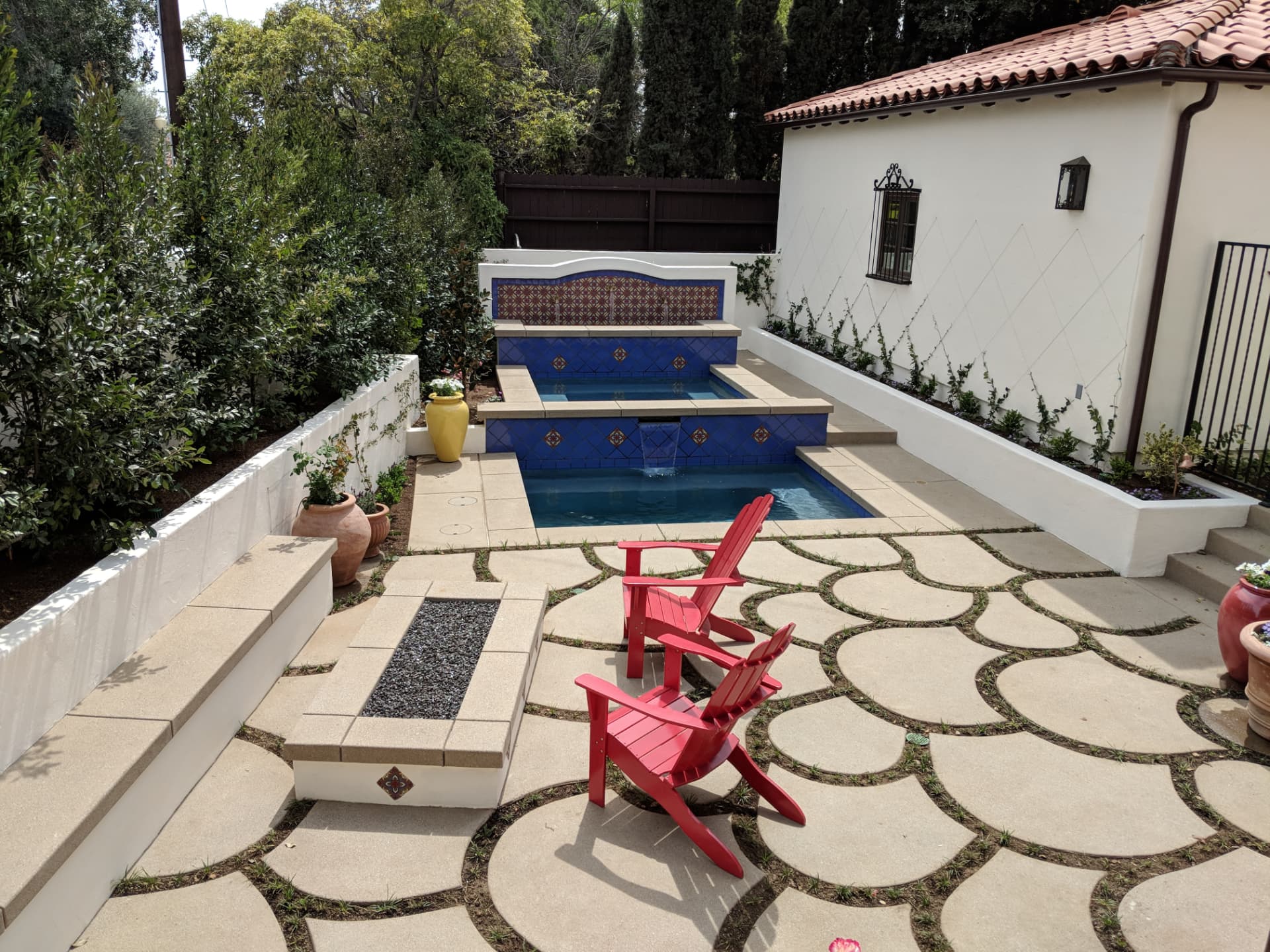 Mission style spa spilling into a pool with cobalt and hand painted tile